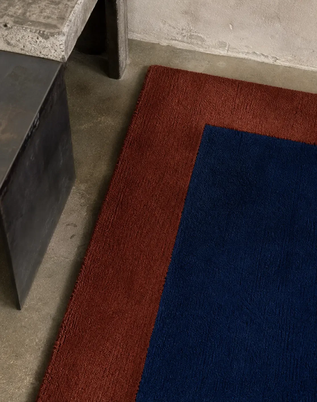 The corner of a cobalt rug with a brick border